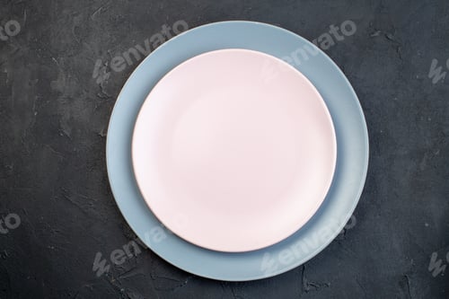 Preview: Close up view of white and blue ceramic empty plates on black background with free space