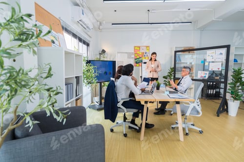 Preview: Business Professionals Discussing Project in Modern Office