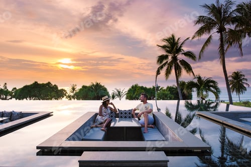 Preview: couple watching sunset in infinity pool on a luxury vacation in Thailand