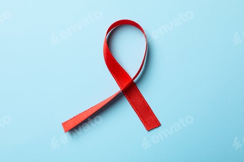Preview: Red awareness ribbon on blue background, close up