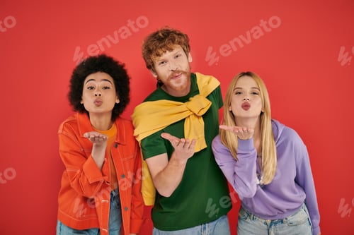 Preview: open relationship, polygamy concept, three interracial lovers blowing air kiss on coral background,