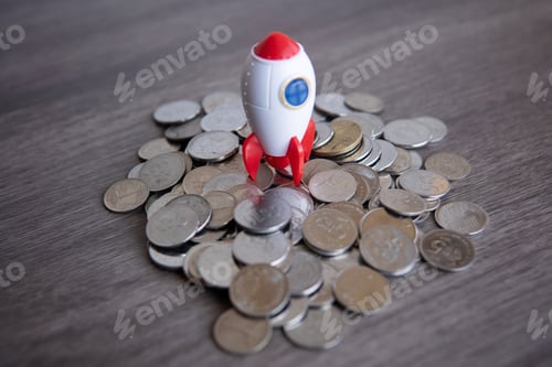 Preview: Closeup image of rocket spaceship and coins.