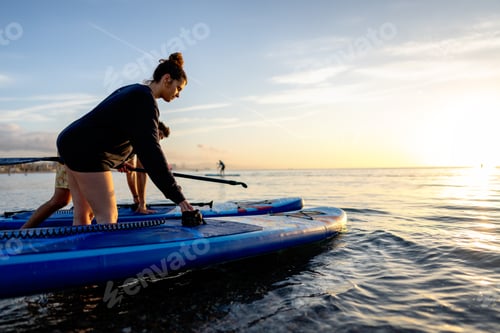Preview: Two people resting by their paddleboards as the sun sets create a mindful outdoor moment