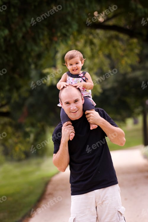 Preview: Father Carries Daughter on Shoulders in Park