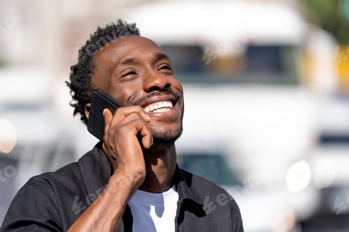 Preview: Cheerful man talking on cell phone in the city