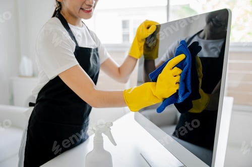 Preview: Young woman using a computer cleaning cloth to disinfect the officeoffice cleaning staff cleaning ma