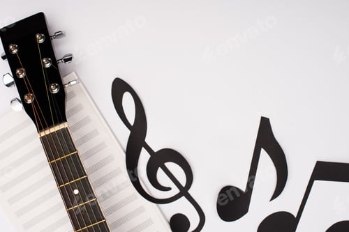 Preview: Top view of paper cut notes near music book and acoustic guitar on white background