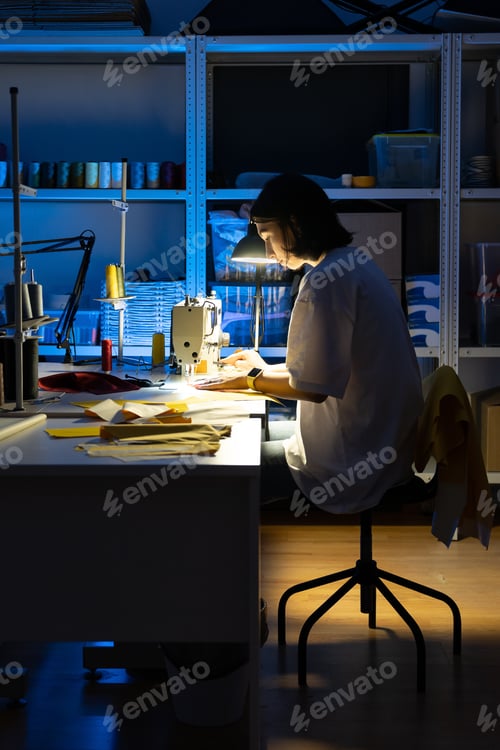 Preview: Dressmaker work on sewing machine. Young tailor sew in professional design studio. Garment industry