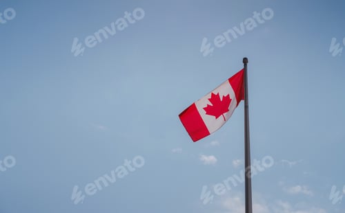 Preview: Flag of Canada flying against a blue sky.