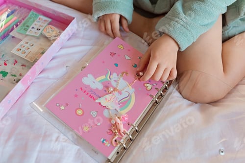 Preview: Girl making handmade notebook during coronavirus covid-19 pandemic quarantine. Stay at home