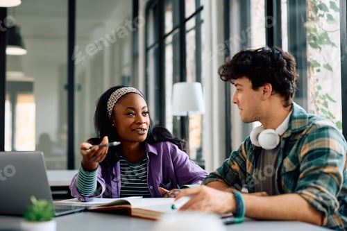 Preview: University students talking while learning for upcoming exams in the classroom.