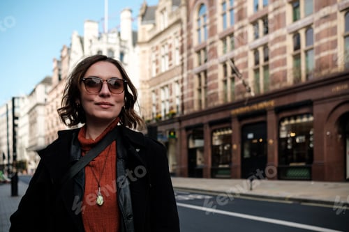 Preview: Woman wearing sunglasses in middle of street.
