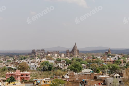 Preview: Aerial view of Orchha Fort in India in the distance, sunlit with a clear blue sky