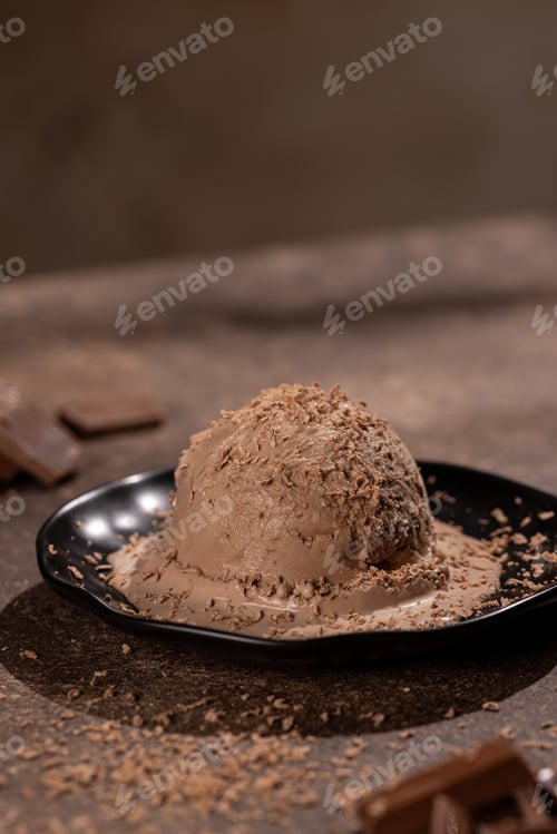 Preview: Scoop of chocolate ice cream with chocolate sprinkles on a black plate