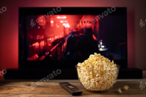 Preview: A glass bowl of popcorn and remote control in the background the TV works.