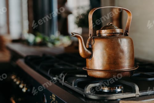 Preview: Bronze kettle in modern kitchen. Old vintage teapot on gas stove