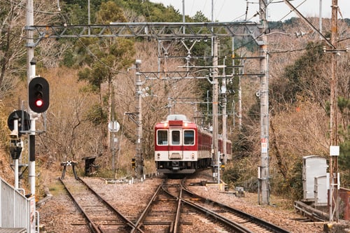 Preview: local train on railway track arriving dry forest to station at Japan