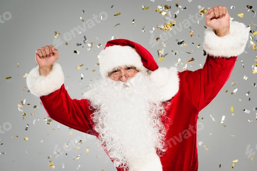 Preview: Excited father christmas showing yes gesture under confetti on grey background