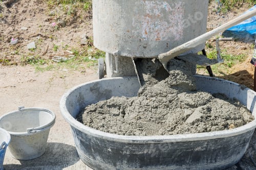Preview: Cement mixer with gray mortar and tan sand churning inside. Blades partially visible, stirring