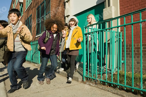 Preview: Children running and smiling outside of school on a sunny day