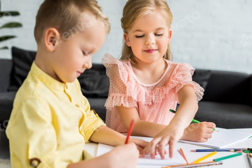 Preview: adorable siblings drawing with colored pencils at home
