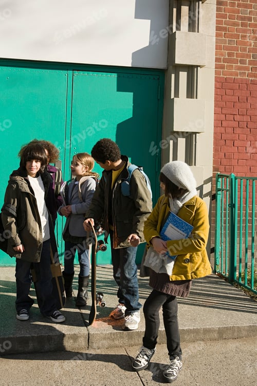 Preview: A diverse group of young students chatting by a green door after school.