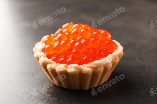 Preview: Tasty canape with red caviar on grey table, closeup