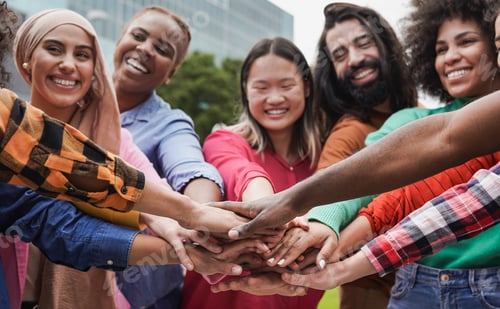 Preview: Group of young multiethnic people stacking hands in the city
