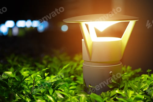 Preview: Luminous electric lamp above the bush in a garden