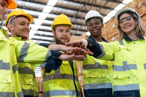 Preview: Group of man and woman workers standing and join hands together in wooden factory