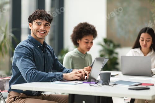 Preview: Arab Businessman Using Laptop Sitting Near Diverse Coworkers In Office