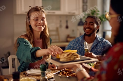 Preview: Happy woman enjoying in Mexican food during a lunch with her friends.