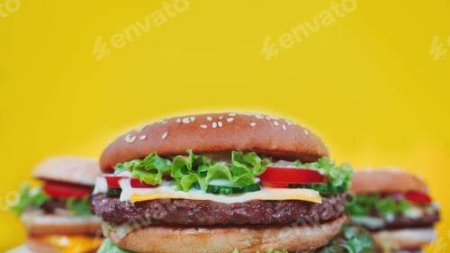 Preview: Fresh homemade grilled burgers and french fries rotating on black smoke background