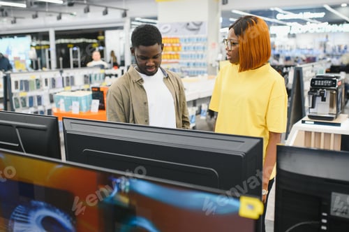 Preview: Beautiful couple buying consumer tech products in modern home appliances store