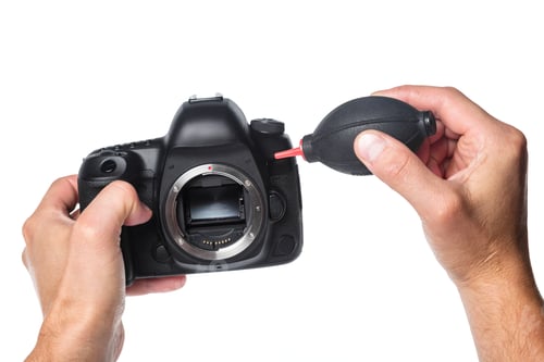Preview: Photo camera in hand isolated on white background