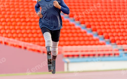 Preview: Close up front view of sport man athlete prosthesis legs is jogging on track in stadium to practice