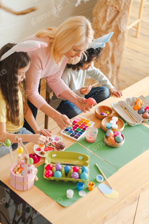 Preview: Woman and children decorating Easter eggs, celebrating spring holiday tradition