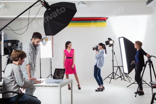 Preview: Photographer photographing fashion model in white backdrop photography studio shoot