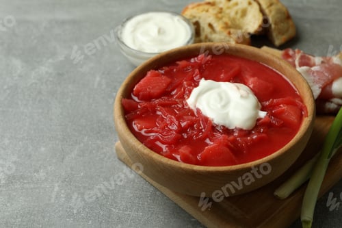 Preview: Concept of tasty eating with borscht and ingredients on gray table