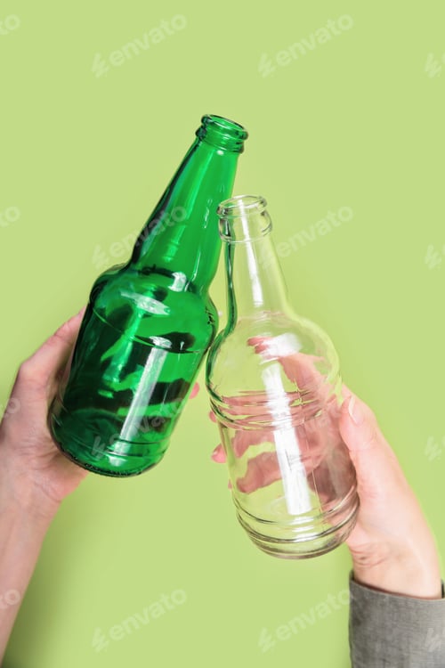 Preview: Two glass bottles in hands showing eco reuse