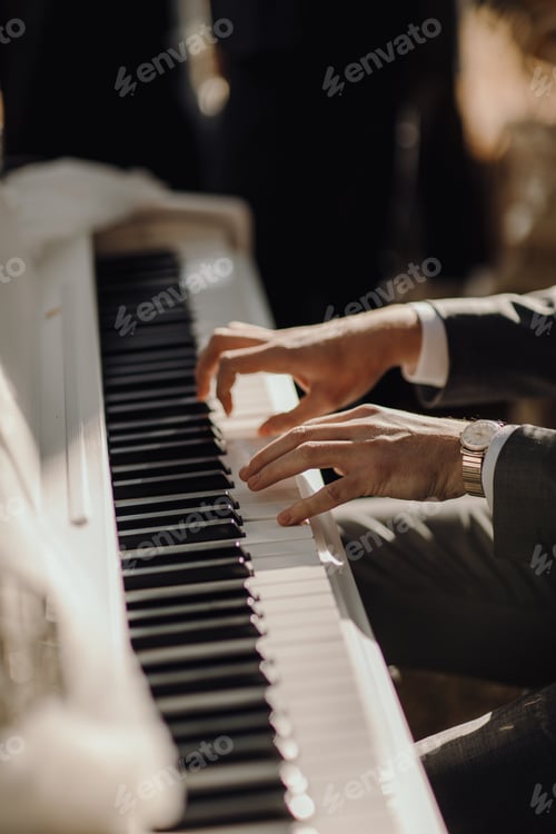 Preview: Close up shot of male playing on the piano. Details of the suit and the watch