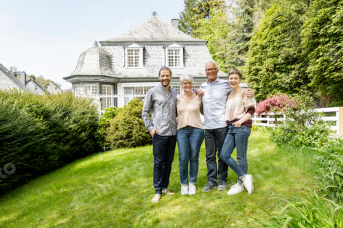 Preview: Happy senior couple with adult children standing in garden of their home