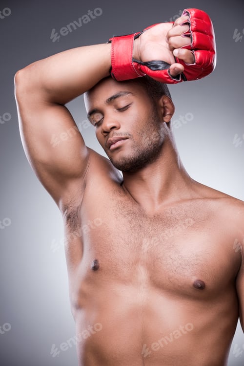 Preview: Shirtless man resting with red boxing glove