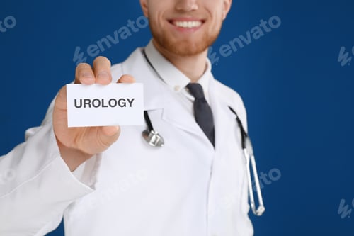 Preview: Male doctor holding card with word UROLOGY on blue background, closeup
