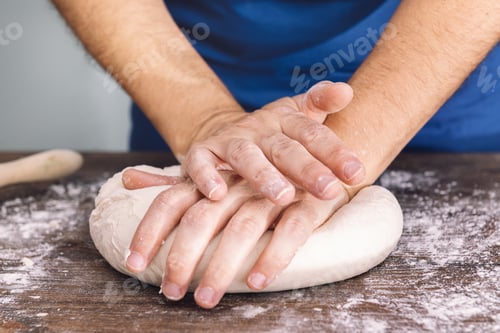 Preview: hands of a woman kneading dough on a wooden table
