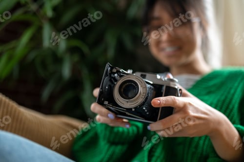 Preview: Photographer. Smiling asian young girl with an old-fashioned camera