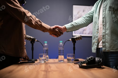 Preview: Podcasters shake hands after a good talk. Concept of podcasts and vlogs