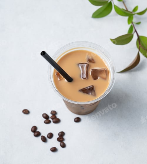 Preview: Iced coffee latte in a recyclable plastic glass with milk and ice on a light background