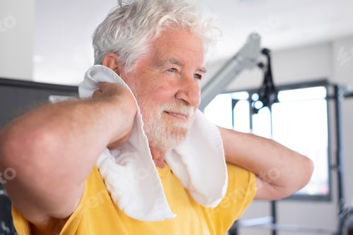 Preview: Close up of attractive bearded senior man after finishing exercises in gym satisfied with his workou