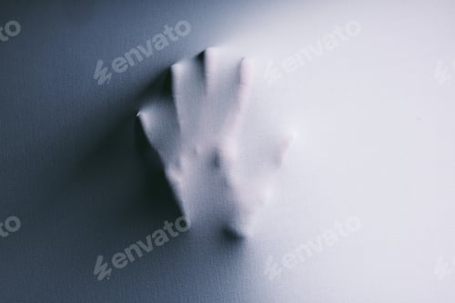 Preview: I cant escape this hell. Shot of hands confined under a sheet trying to press through.
